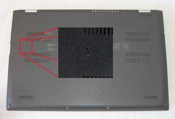 A typical pinhole battery reset button on the bottom of a laptop