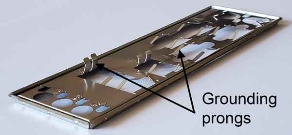 Photo of a motherboard IO shield showing the grounding prongs